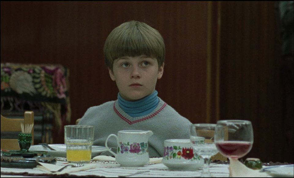 Still from Budapest Diaries: a boy at a table set with teacups and wine glasses