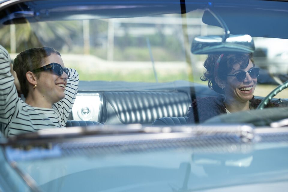 Still from Life Is: two women laughing in a convertible