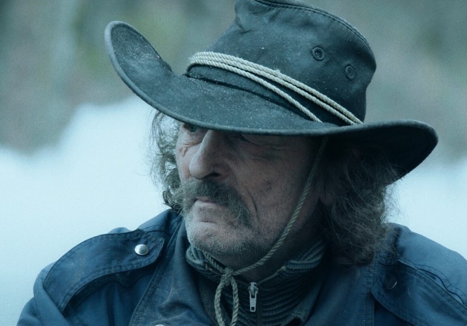 Still from Torn: Kalju in a wide-brimmed hat in the forest